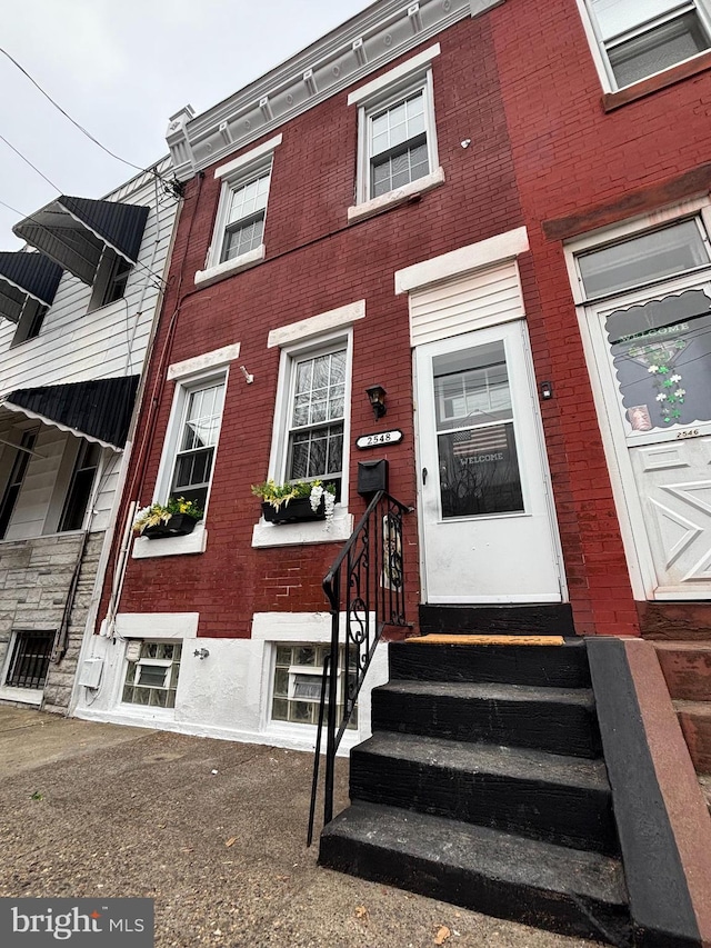 view of front of property featuring entry steps and brick siding