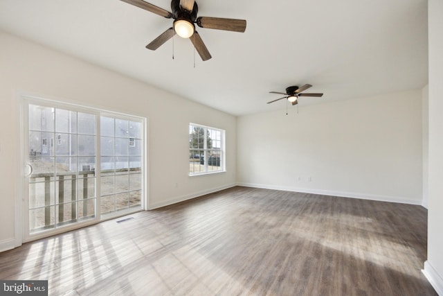 spare room featuring ceiling fan, wood finished floors, visible vents, and baseboards