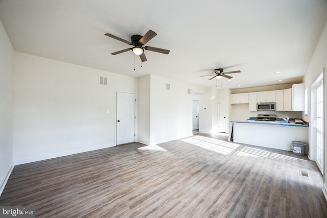 unfurnished living room with visible vents, baseboards, ceiling fan, wood finished floors, and recessed lighting