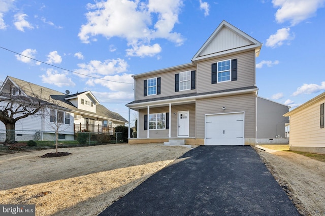 view of front of home featuring covered porch, driveway, an attached garage, and fence