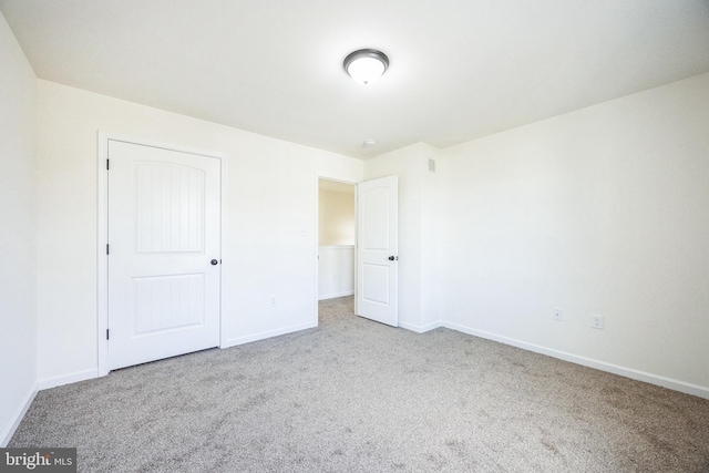 unfurnished bedroom with visible vents, a closet, baseboards, and carpet flooring