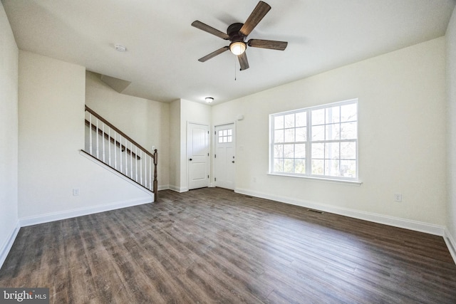 unfurnished living room with baseboards, stairs, visible vents, and dark wood-style flooring