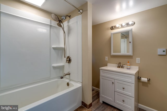 full bath featuring baseboards, vanity, shower / bathtub combination, and wood finished floors