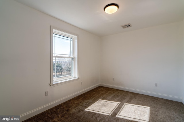 spare room featuring carpet, visible vents, and baseboards