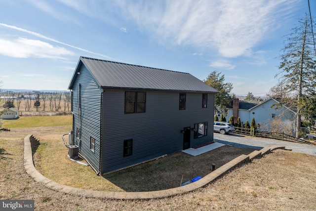 view of home's exterior with central air condition unit and metal roof