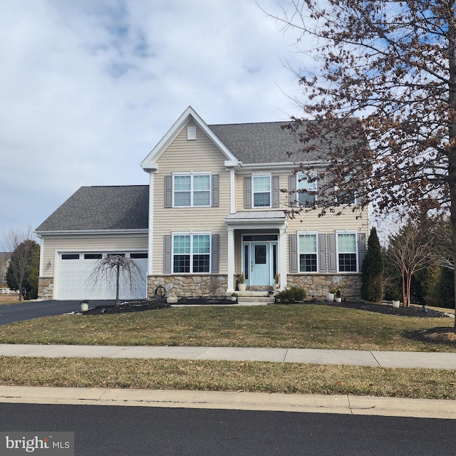 view of front of property with a garage, stone siding, a front lawn, and aphalt driveway