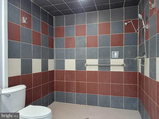 full bathroom with tiled shower and toilet