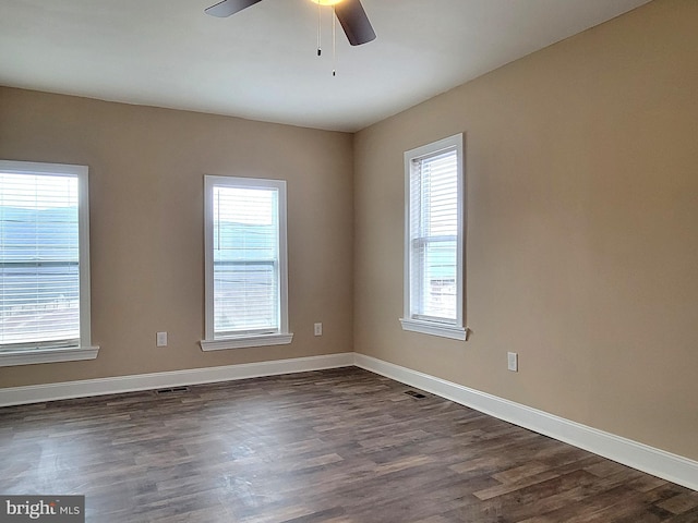 spare room with dark wood-type flooring and baseboards