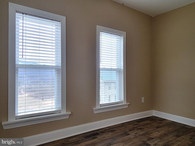 unfurnished room featuring dark wood-style floors and baseboards