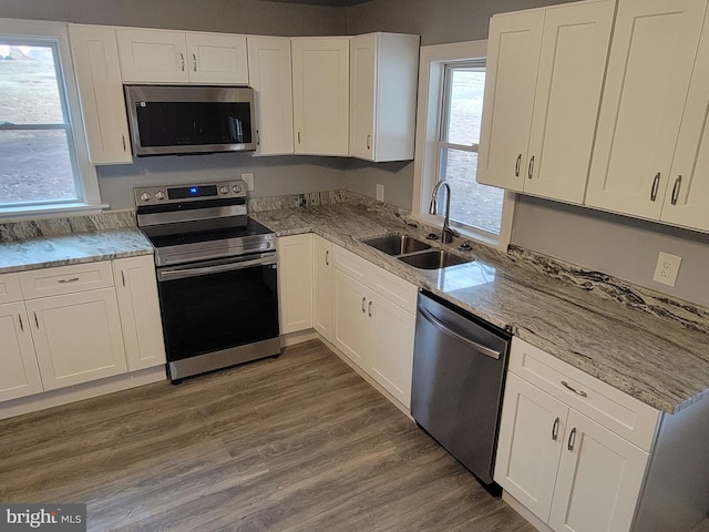 kitchen featuring stainless steel appliances, a sink, dark wood finished floors, and white cabinets