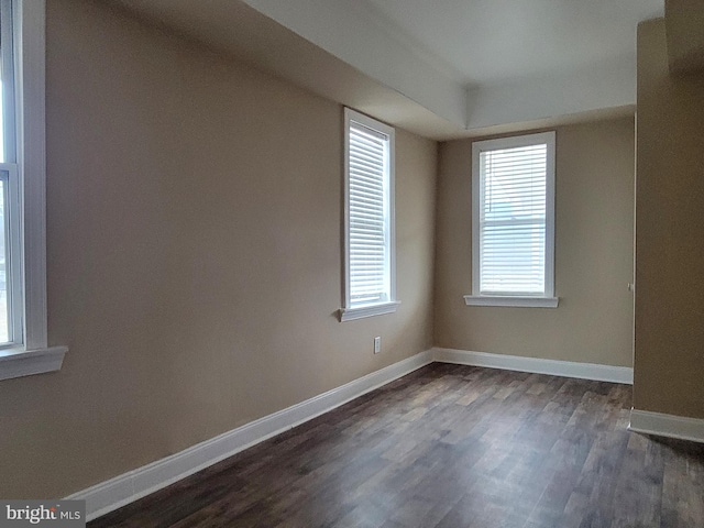 empty room featuring dark wood finished floors and baseboards