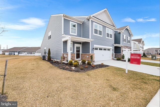 view of front of house with a front lawn, a residential view, driveway, and an attached garage