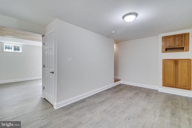 basement featuring light wood-style flooring and baseboards