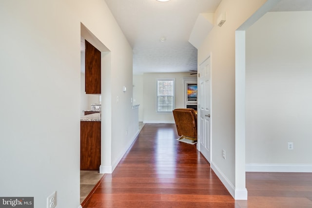 corridor with wood finished floors and baseboards