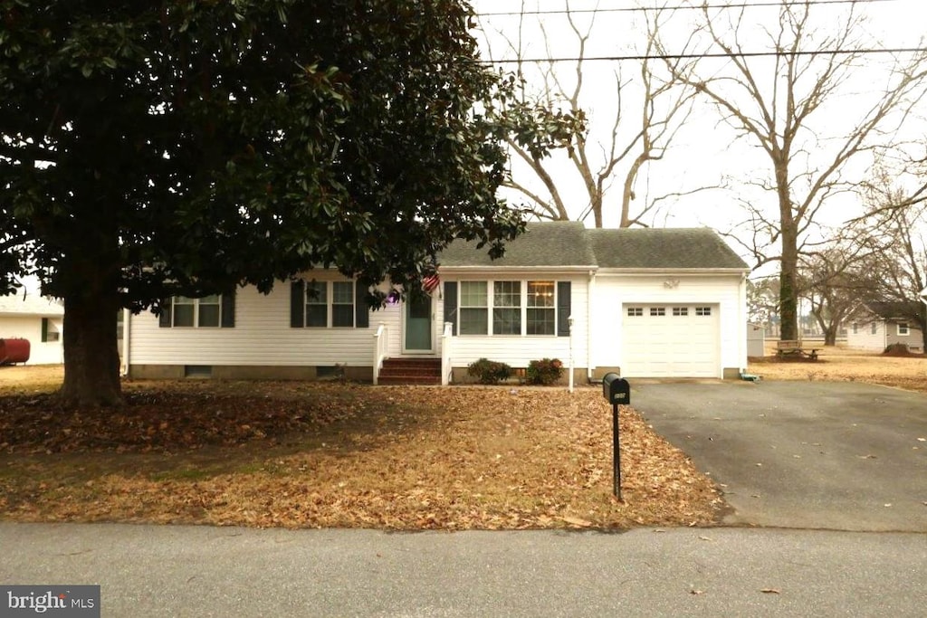 ranch-style house with a garage, aphalt driveway, and entry steps