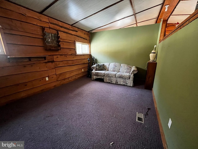 unfurnished room with wood walls, visible vents, and carpet flooring