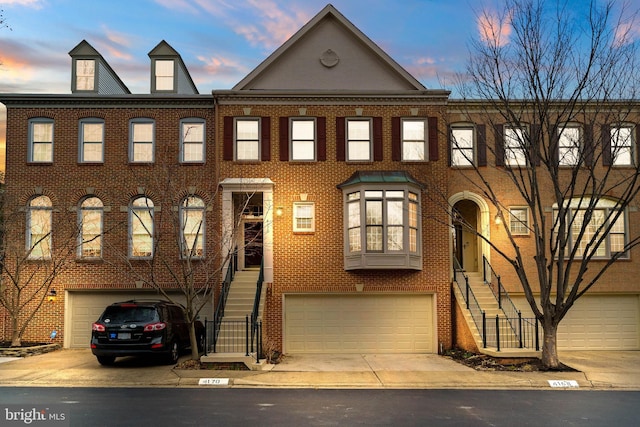 townhome / multi-family property featuring brick siding and stairway