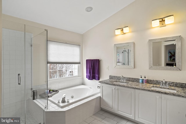 full bathroom featuring a whirlpool tub, a stall shower, double vanity, and a sink