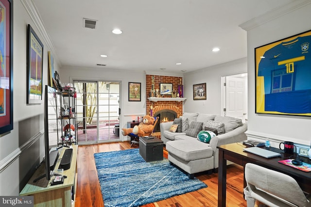 living area featuring visible vents, ornamental molding, wood finished floors, a fireplace, and recessed lighting