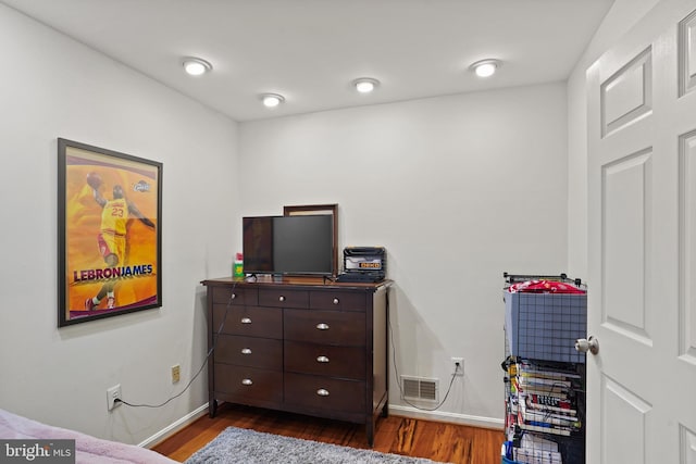 bedroom with dark wood-type flooring, visible vents, and baseboards