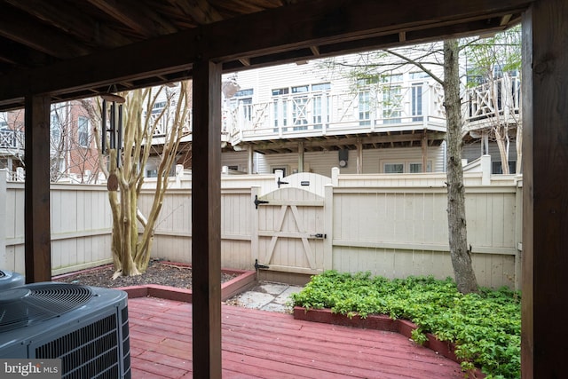 wooden deck featuring a gate, fence, and cooling unit