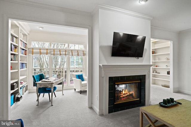 living room with carpet floors, a tiled fireplace, built in features, and crown molding