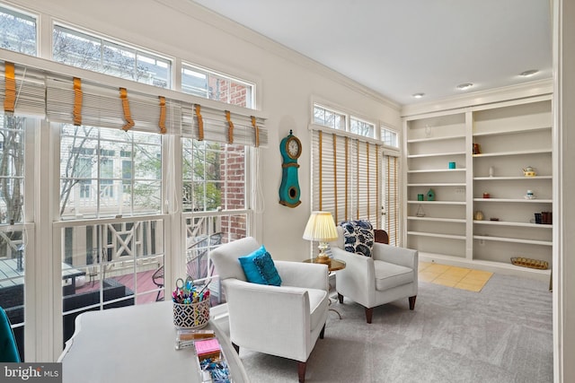 sitting room featuring ornamental molding, carpet, and built in shelves