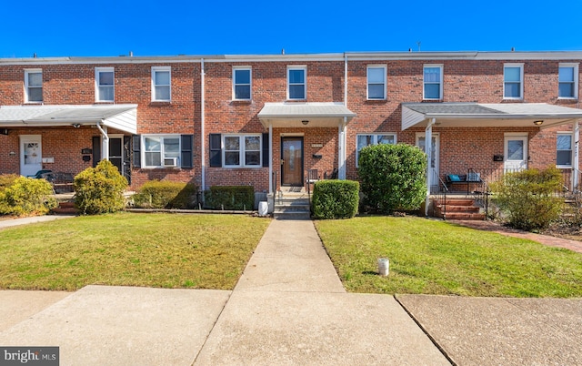 view of property featuring a front lawn and brick siding