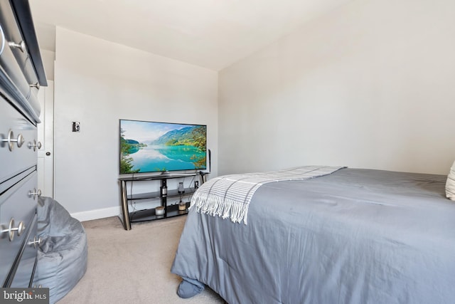 bedroom featuring baseboards and light colored carpet