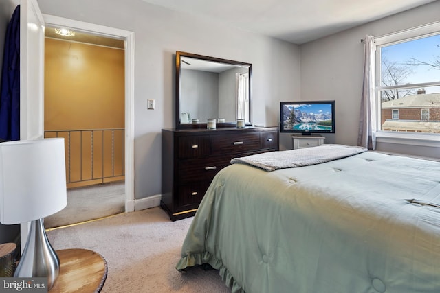 bedroom with light carpet and baseboards