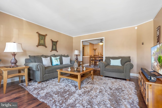 living area with ceiling fan, baseboards, wood finished floors, and ornamental molding