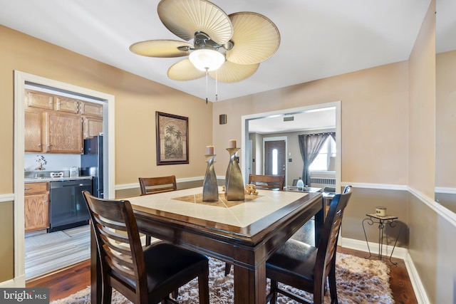 dining room with light wood-type flooring, baseboards, and a ceiling fan