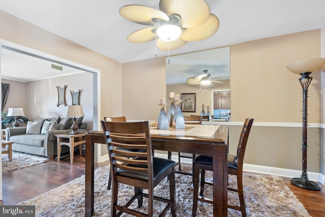 dining space with ceiling fan, baseboards, and wood finished floors