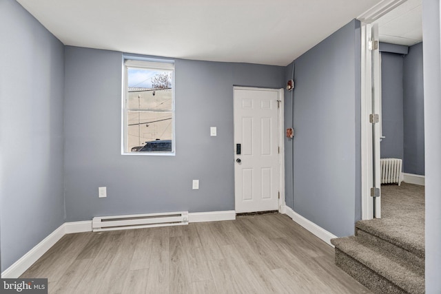 foyer entrance with baseboards, radiator heating unit, a baseboard radiator, and light wood-style floors