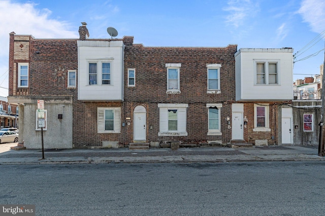 view of property with entry steps and brick siding