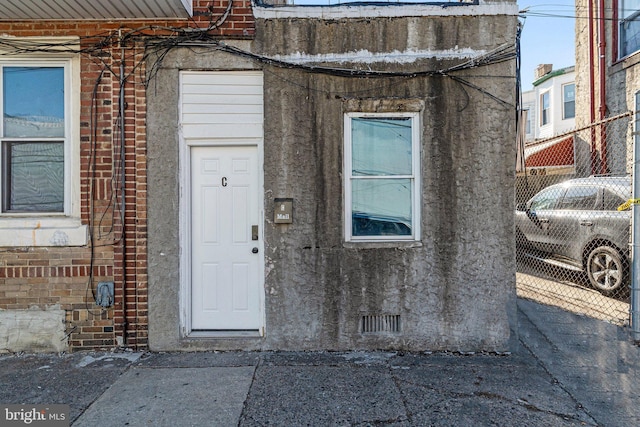 property entrance featuring brick siding and crawl space