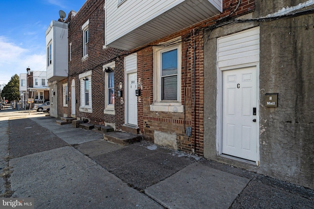 view of exterior entry featuring brick siding