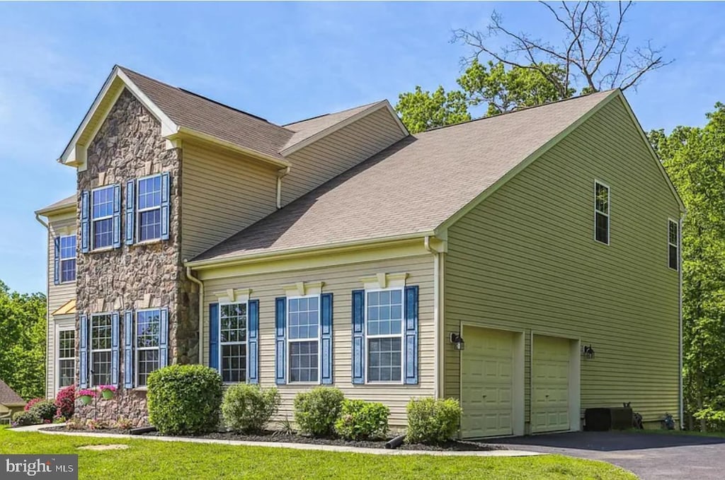 view of front facade featuring aphalt driveway and stone siding