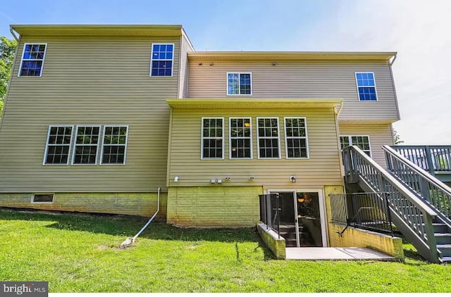 back of house featuring stairs and a yard