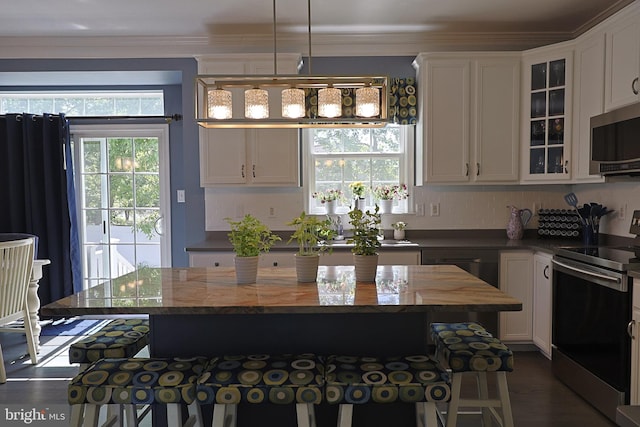 1 Longfellow Ln, Hainesport, NJ 08036 - kitchen featuring appliances with stainless steel finishes, white cabinets, glass insert cabinets, ornamental molding, and a kitchen island