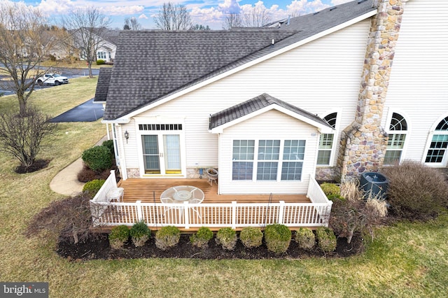 rear view of property with a shingled roof, french doors, a yard, and a deck