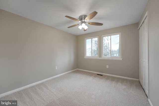 unfurnished bedroom with a closet, light colored carpet, visible vents, and baseboards