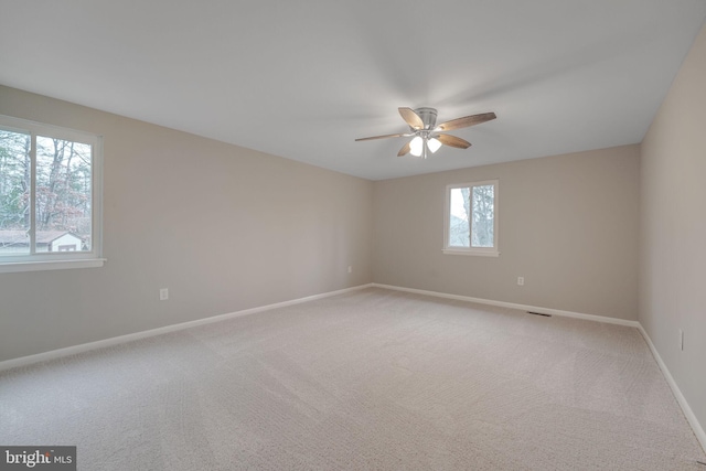 unfurnished room featuring light carpet, ceiling fan, and baseboards