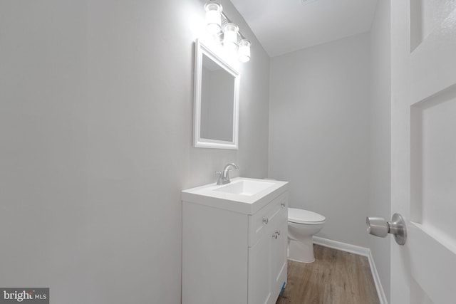 bathroom with vanity, wood finished floors, and toilet