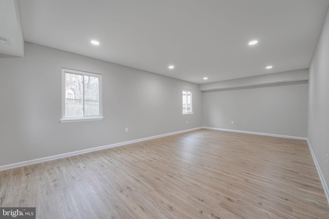 unfurnished room with baseboards, recessed lighting, and light wood-style floors