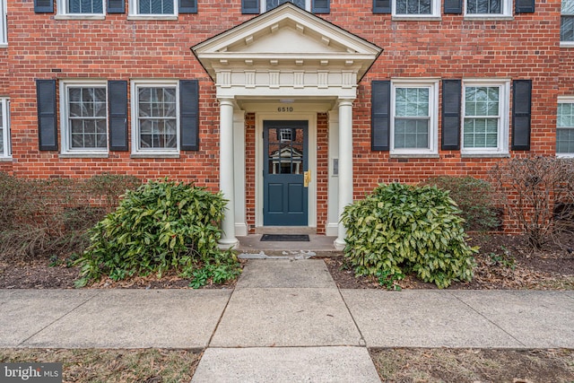 doorway to property featuring brick siding