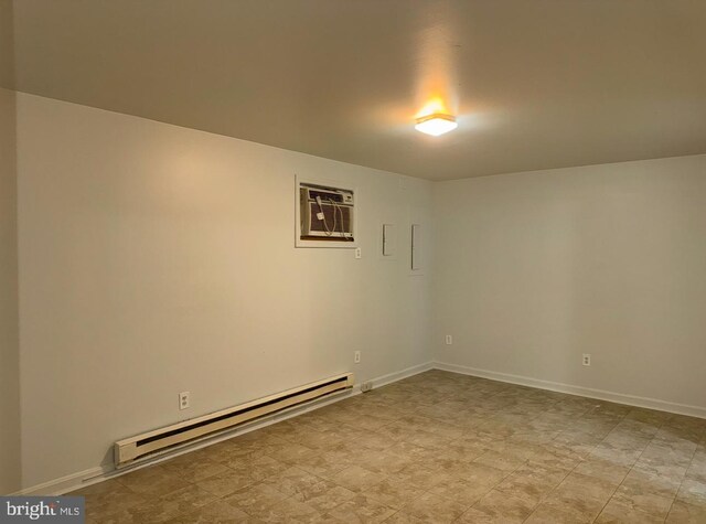 empty room with a baseboard heating unit, a wall mounted AC, and baseboards