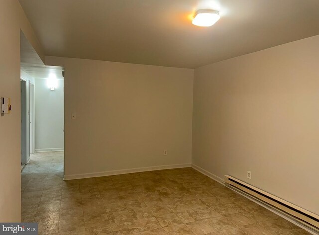 unfurnished room with baseboard heating and baseboards