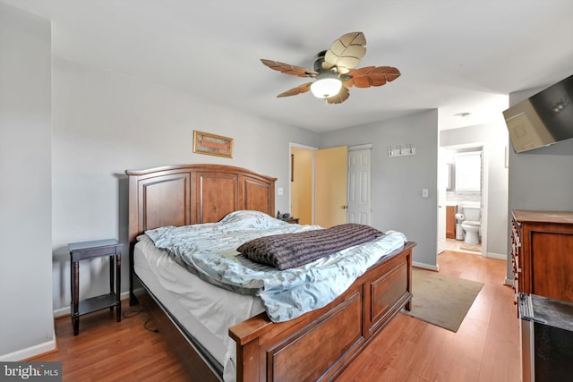 bedroom featuring ensuite bath, light wood-style flooring, and baseboards