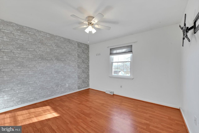 unfurnished room with a ceiling fan, baseboards, visible vents, and wood finished floors